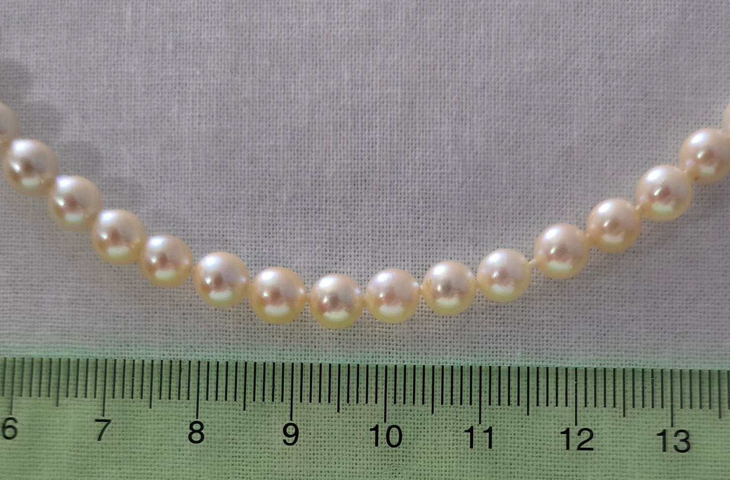 22" Japanese Akoya pearl necklace. Pearls sized between 6.5mm and 7mm each. Great mirror surface and few inclusions. The pearls are white with a gold hue.